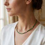 A solid line of green is hard to beat, but this version of a tennis necklace feels more de — necklace lifestyle shot, Close-up of the necklace on a woman's neck from the side