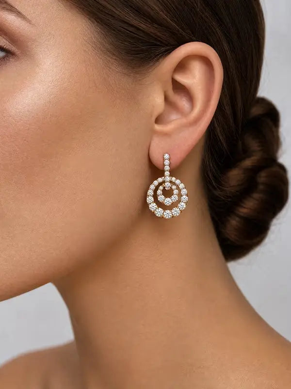 A close-up of a dangling spiral diamond fine jewelry earring in 18K gold from The Private Room Fine Jewelry