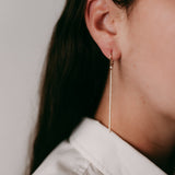 Lifestyle - Long diamond bar earrings on ear in 18k rose gold 
