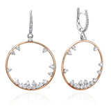 Packshot - A pair of round diamond snowflake earrings, with a rose gold hoop and a white gold huggie hoop, adorned with diamonds.
